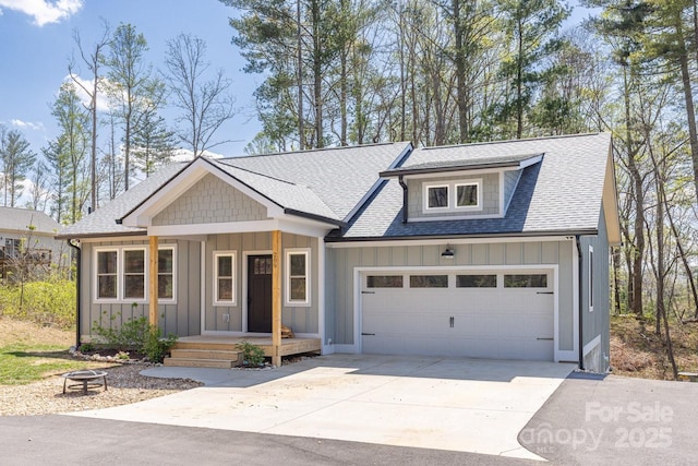 209 Fall Leaves Dr, Fairview, NC 28730 - view of front of home with board and batten siding, driveway, roof with shingles, a fire pit, and a garage
