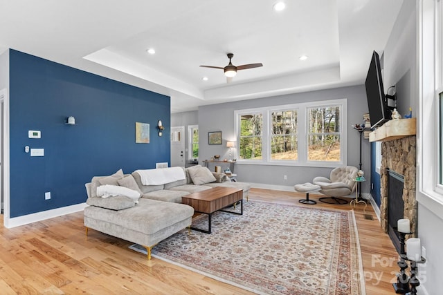 209 Fall Leaves Dr, Fairview, NC 28730 - living area featuring a tray ceiling, a ceiling fan, light wood-style floors, a fireplace, and recessed lighting