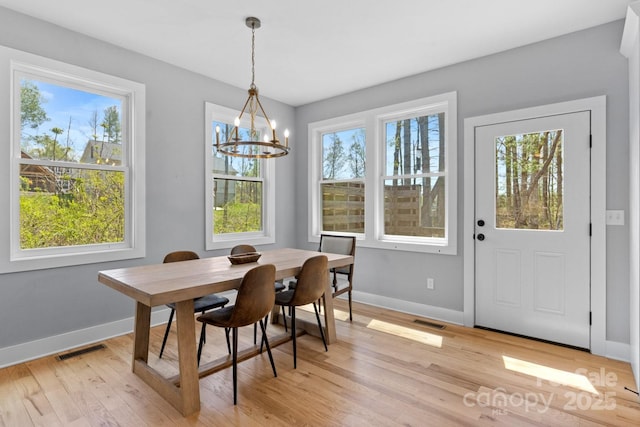 209 Fall Leaves Dr, Fairview, NC 28730 - dining space with light wood-type flooring and a chandelier