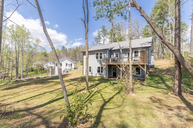 209 Fall Leaves Dr, Fairview, NC 28730 - rear view of property with a deck, board and batten siding, a lawn, and roof with shingles