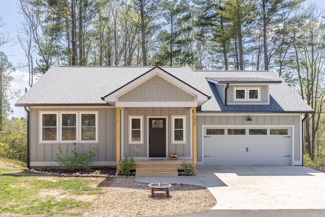 209 Fall Leaves Dr, Fairview, NC 28730 - view of front of house with board and batten siding, roof with shingles, driveway, an attached garage, and an outdoor fire pit