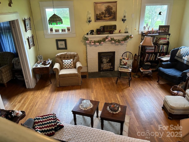 212 S Mitchell Ave, Bakersville, NC 28705 - living room with a fireplace with raised hearth, light wood-type flooring, plenty of natural light, and visible vents