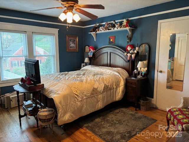 212 S Mitchell Ave, Bakersville, NC 28705 - bedroom featuring a wall mounted air conditioner, ceiling fan, and wood finished floors