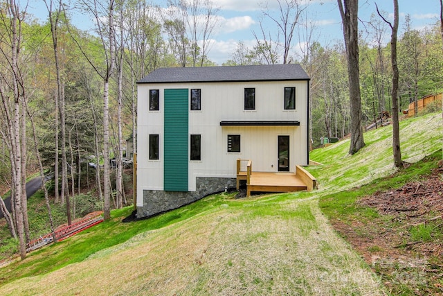 back of property featuring a lawn and a deck