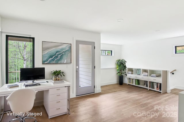 office space with baseboards and light wood-style flooring