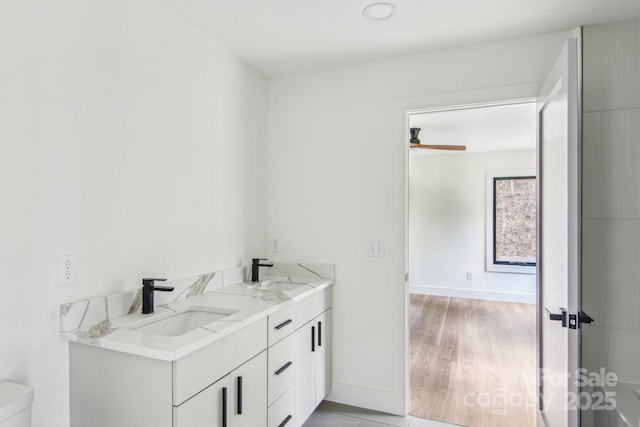 full bathroom with baseboards, a sink, and toilet