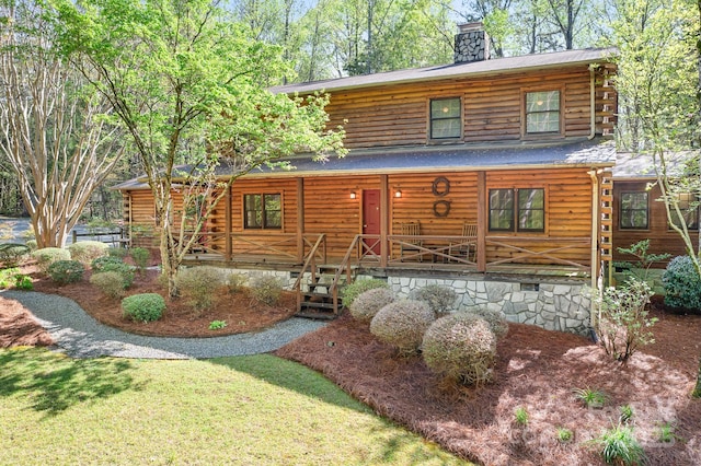 cabin with crawl space, a chimney, log siding, and a porch