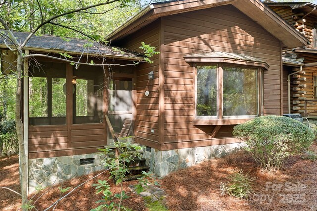 view of side of property with a sunroom and crawl space