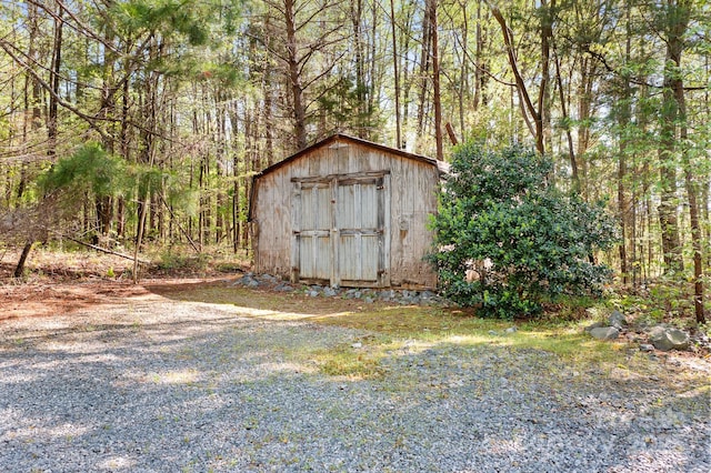 view of shed with a wooded view