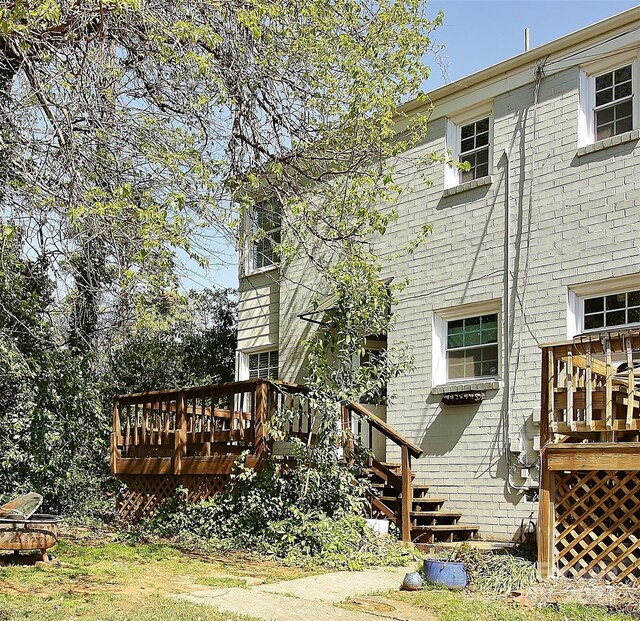 rear view of house with brick siding and a wooden deck