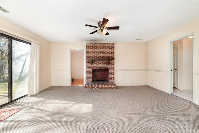 unfurnished living room featuring crown molding, carpet flooring, ceiling fan, visible vents, and a fireplace