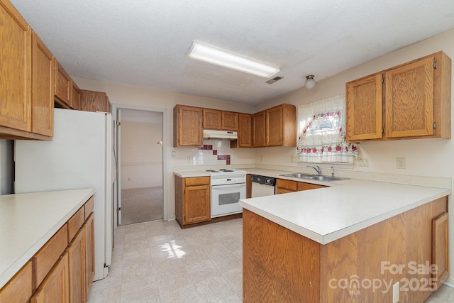 kitchen with light countertops, white appliances, under cabinet range hood, a sink, and light floors