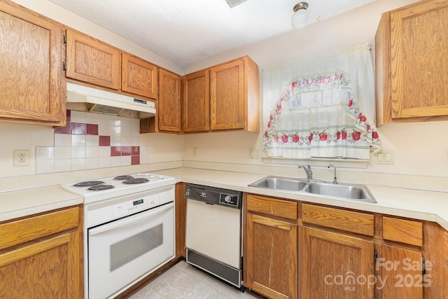 kitchen with light countertops, white appliances, under cabinet range hood, a sink, and backsplash