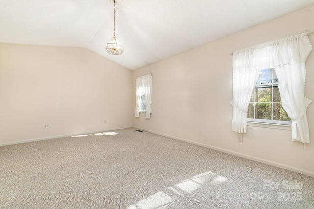 empty room with baseboards, lofted ceiling, visible vents, and carpet floors