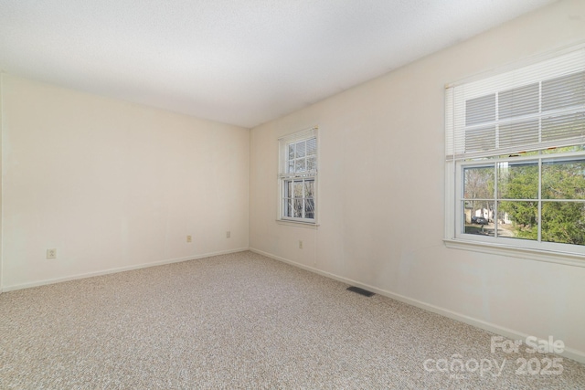 spare room featuring carpet, baseboards, and visible vents