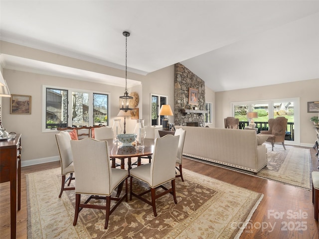 12 Clubside Dr, Asheville, NC 28804 - dining space with a stone fireplace, baseboards, lofted ceiling, and wood finished floors