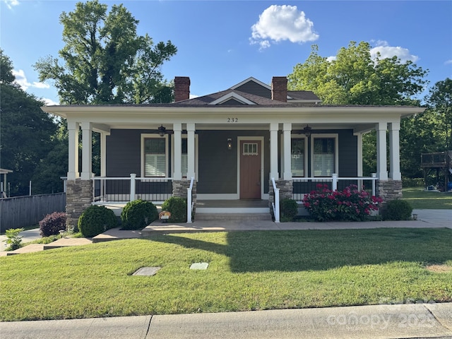 view of front of house featuring a ceiling fan, covered porch, and a front lawn
