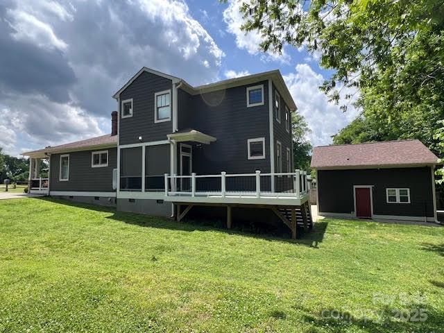 back of house featuring a deck, a lawn, stairs, and crawl space