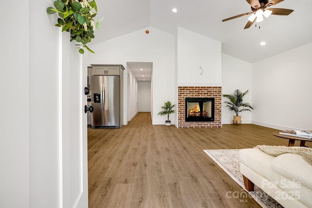 37 Garland Ball Dr, Alexander, NC 28701 - living room featuring vaulted ceiling, ceiling fan, baseboards, light wood-style floors, and a brick fireplace