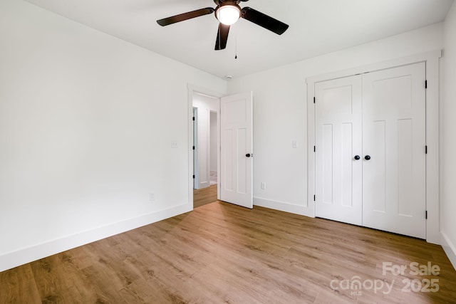 37 Garland Ball Dr, Alexander, NC 28701 - unfurnished bedroom featuring baseboards, light wood finished floors, a ceiling fan, and a closet