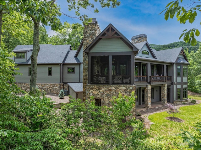 45 Fates Overlook Loop, Black Mountain, NC 28711 - rear view of house featuring stone siding, a chimney, a patio area, a shingled roof, and a sunroom