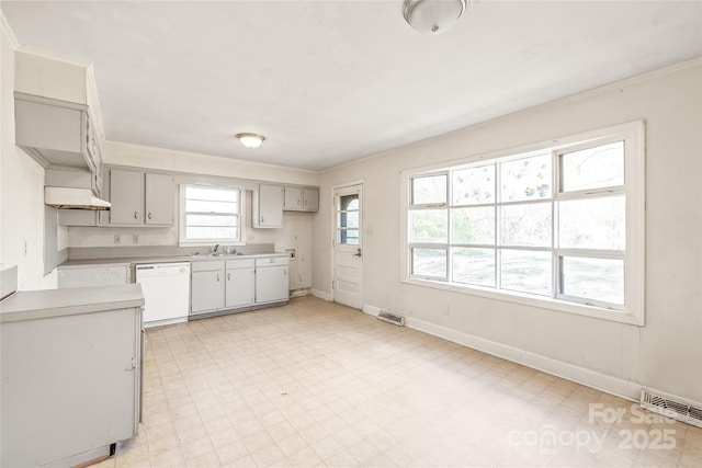 kitchen with baseboards, light floors, dishwasher, and crown molding