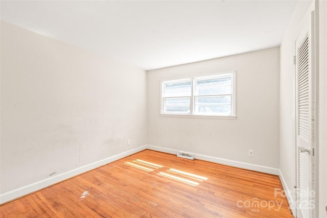 unfurnished bedroom with wood finished floors, visible vents, and baseboards