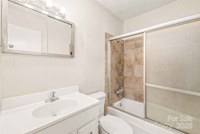 full bathroom featuring enclosed tub / shower combo, toilet, and vanity