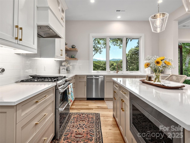 162 Riverbend Forest Dr, Asheville, NC 28805 - kitchen featuring decorative backsplash, light countertops, visible vents, light wood finished floors, and appliances with stainless steel finishes