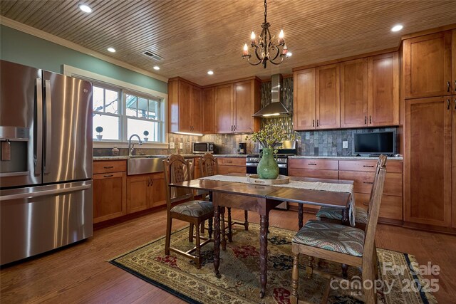 570 Lambs Grill Rd, Rutherfordton, NC 28139 - kitchen with a sink, wall chimney exhaust hood, wood finished floors, appliances with stainless steel finishes, and brown cabinets