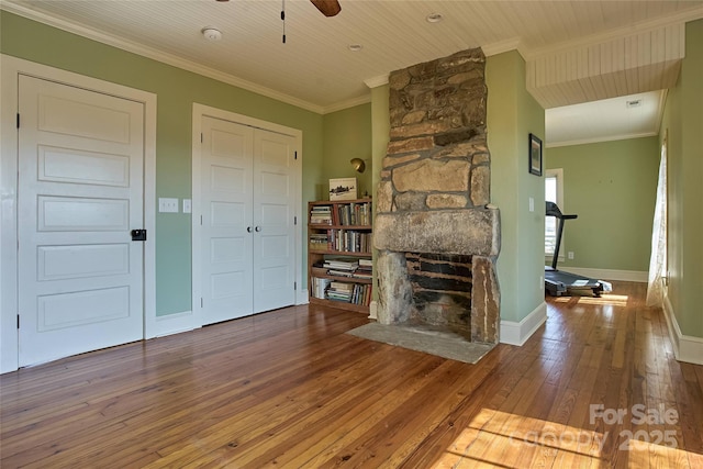 570 Lambs Grill Rd, Rutherfordton, NC 28139 - unfurnished living room with baseboards, ceiling fan, ornamental molding, a stone fireplace, and wood-type flooring
