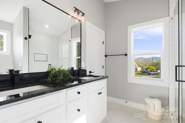 bathroom with baseboards, a shower stall, a sink, and marble finish floor