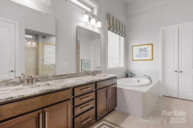 full bathroom featuring double vanity, a tile shower, a sink, and a garden tub