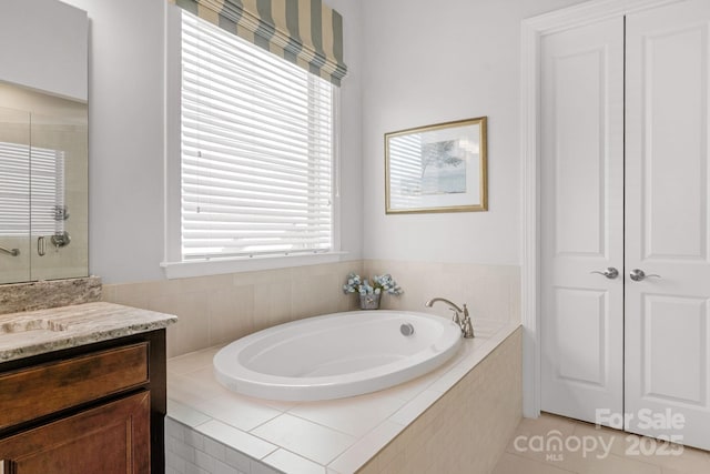 full bath featuring vanity, a tile shower, and a garden tub