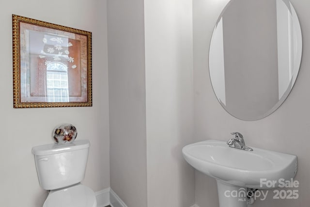 half bathroom featuring toilet and a sink