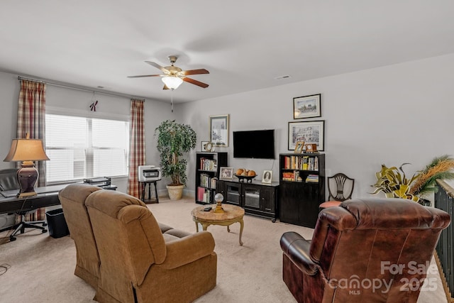 living room with visible vents, light colored carpet, and ceiling fan
