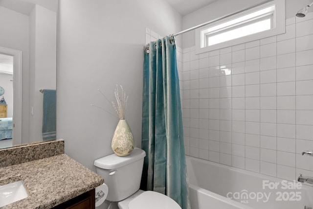 full bath with toilet, vanity, and shower / bath combo with shower curtain