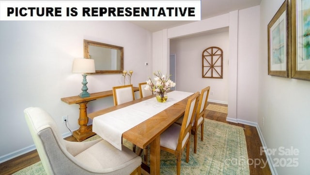 dining space featuring baseboards and wood finished floors