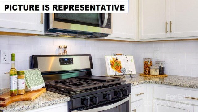 kitchen featuring backsplash, light stone countertops, white cabinetry, and stainless steel appliances