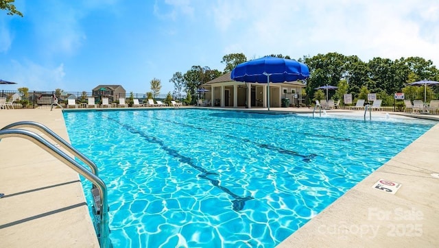 community pool featuring fence and a patio