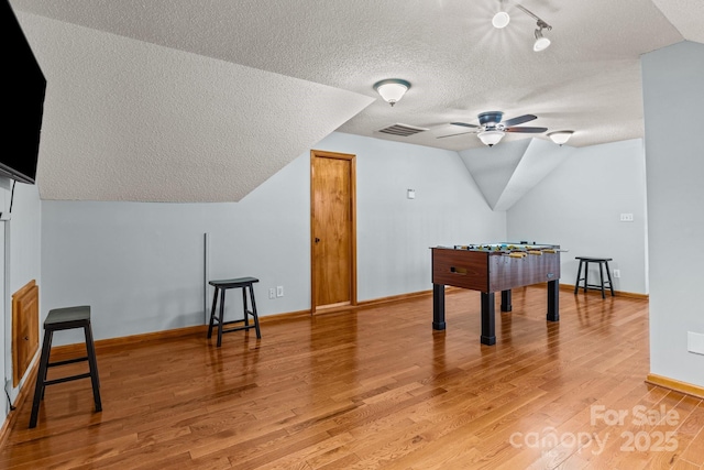 7146 Sifford Rd, Stanley, NC 28164 - recreation room featuring a textured ceiling, vaulted ceiling, baseboards, light wood-style flooring, and ceiling fan