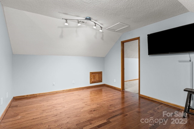 7146 Sifford Rd, Stanley, NC 28164 - additional living space with wood finished floors, lofted ceiling, a textured ceiling, attic access, and baseboards