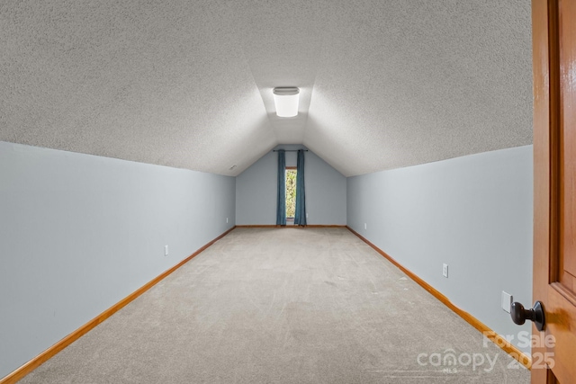7146 Sifford Rd, Stanley, NC 28164 - bonus room with baseboards, light colored carpet, lofted ceiling, and a textured ceiling
