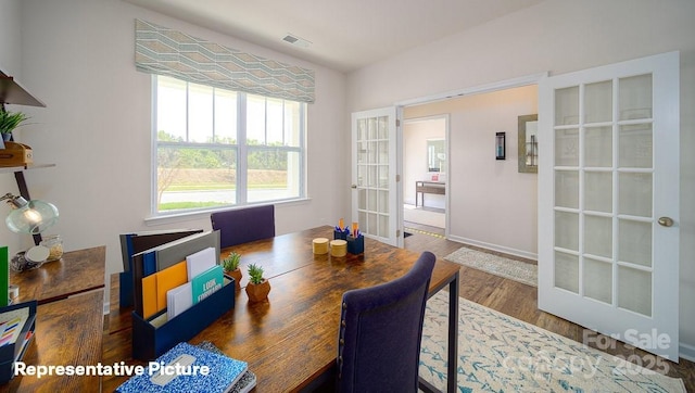 dining area featuring baseboards, visible vents, french doors, and wood finished floors