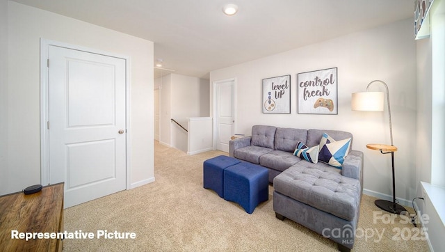 carpeted living area featuring baseboards and recessed lighting