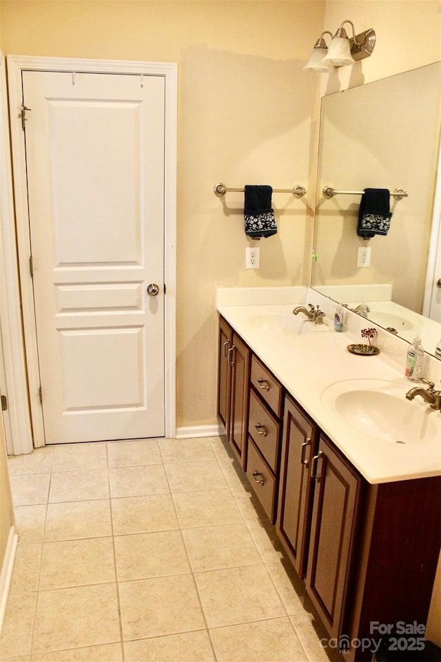bathroom featuring a sink, tile patterned flooring, and baseboards