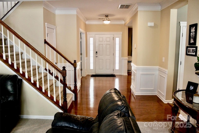 foyer featuring crown molding, stairs, visible vents, and dark wood finished floors