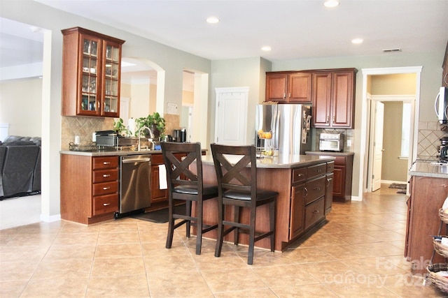 kitchen with a breakfast bar area, visible vents, appliances with stainless steel finishes, decorative backsplash, and recessed lighting