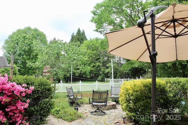 view of yard featuring a fire pit, a patio area, and fence