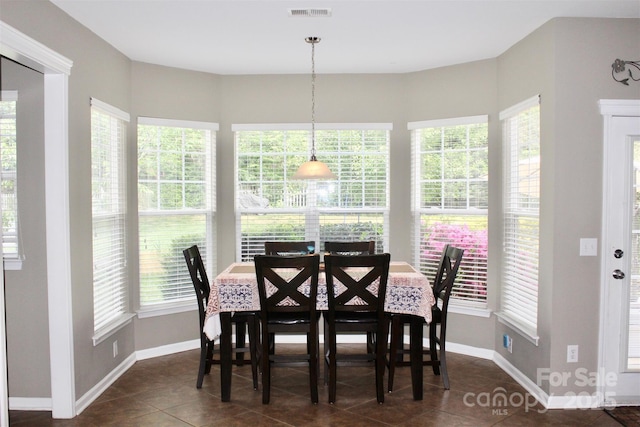 dining room with a wealth of natural light, visible vents, and dark tile patterned floors